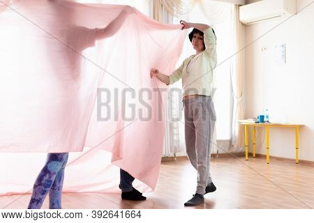 Select Focuc. Women Dance In A Fitness Room With Large Windows. Around Large Transparent Fabrics And