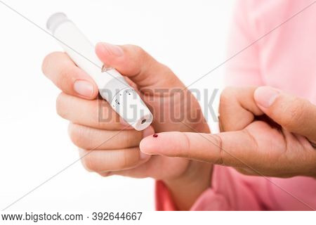 Closeup Woman Measuring Glucose Level Using A Hand Test Lancelet On The Finger She Monitors High Blo