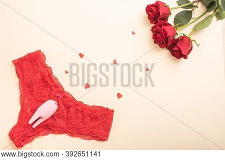 Flat Lay. Womens Red Lace Panties Clitoral Vibrator And Scarlet Roses. The Best Gift For A Woman For
