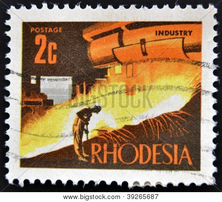 RHODESIA - około 1971: Znaczek wydrukowany w Rhodesia pokazuje obraz przemysłu około 1971