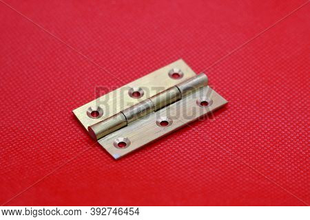 Brass Hinge Without Screws Against Plain Red Background With Copyspace