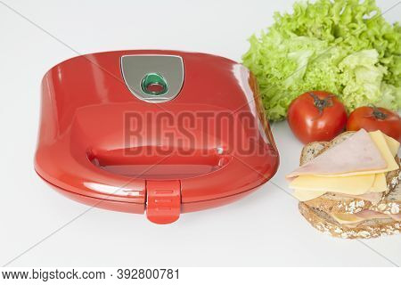 Sandwich Maker Red With Food; Photo On White Background.