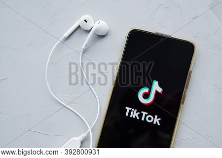 Tver, Russia-february 12, 2020 Tik Tok Logo On The Smartphone Screen And White Wireless Headphones O