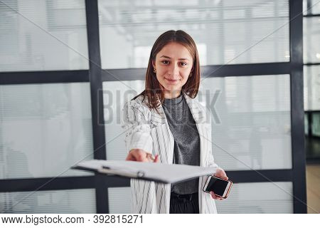 Portrait Of Young Woman In White Formal Clothes That Standing Indoors.
