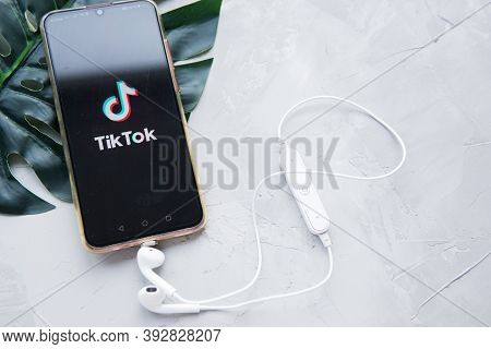 Tver, Russia-february 12, 2020 Tik Tok Logo On The Smartphone Screen And White Wireless Headphones O
