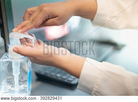 The Female Hand Pushing The Alcohol Gel While Woking With The Computer Laptor For Preventive Covid-1