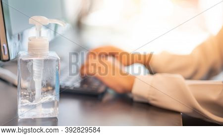 The Female Hand Typing Keyboard With The Computer Laptor And Alcohol Gel Put On Beside The Computer 