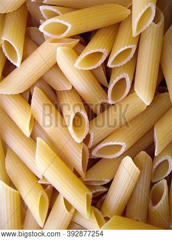 Raw Pasta. Penne Flat Lay. Pasta Secco Photo Texture. Dry Pasta Penne Scatter Top View. Whole Wheat 