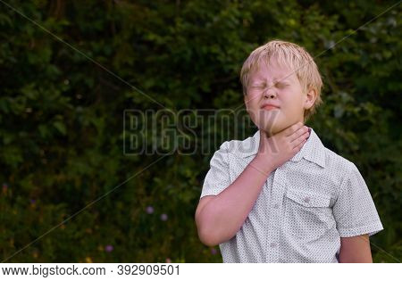 The Boy Holds His Hand To His Throat And Winces At The Pain In The Park