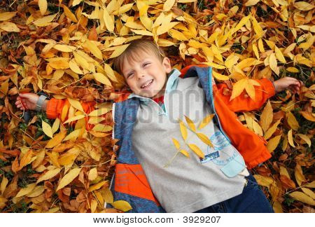 Happy Child è bugia su erba autunnale giallo foglia
