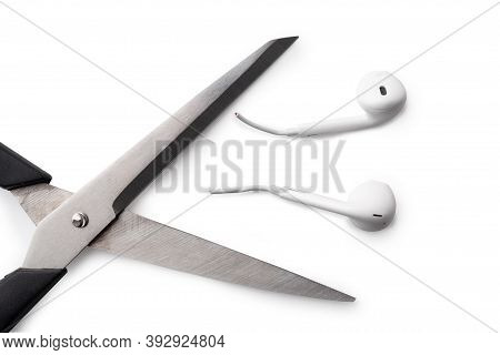 Conceptual Photo Of Cut Off The Earphones Wire. Bluetooth Headphones Are A New Trend. Wireless Techn