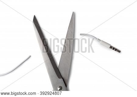 Conceptual Photo Of Cut Off The Earphones Wire. Bluetooth Headphones Are A New Trend. Wireless Techn