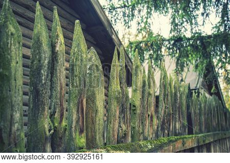 Ancient Style Wooden Wall Palisade. High Wooden Antique Palisade. Fence Made Of Sharp Wooden Stakes 