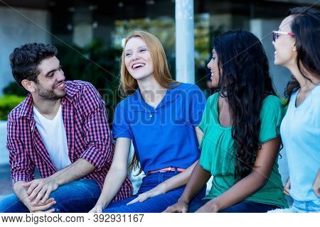 Group Of Jobless Young Adults Talking And Relaxing Outdoor In City