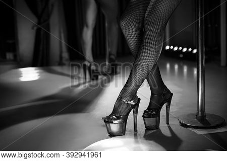Heels Of Sexy Woman Pole Dancing Or Striptease. Pylon In Night Club. Stripper Girl Background