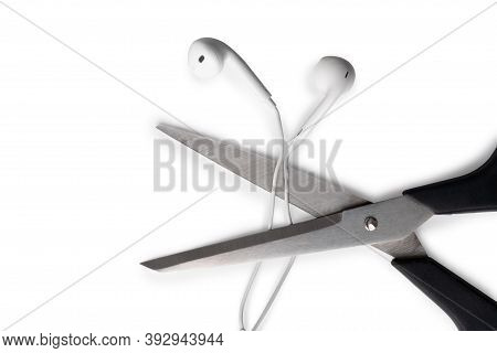 Conceptual Photo Of Cut Off The Earphones Wire. Bluetooth Headphones Are A New Trend. Wireless Techn