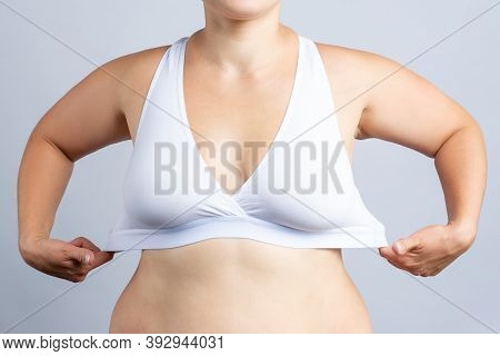 Big Natural Breasts In White Bra Close-up On Gray Background