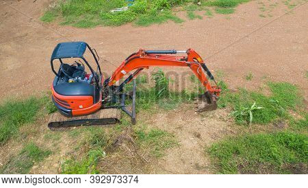 Aerial View Of Construction Tractor Car, Bulldozer, Or Backhoe Digging Road Or Street In Transportat
