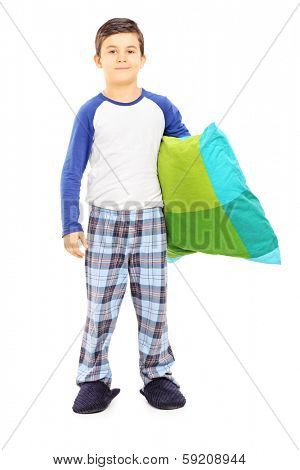 Full length portrait of boy in pajamas holding a pillow isolated on white background