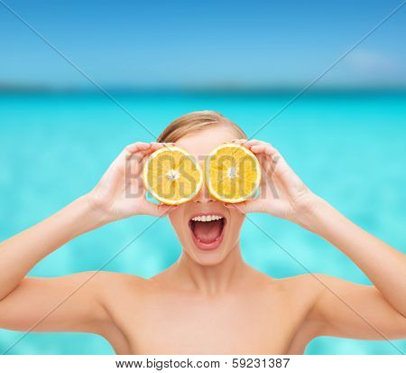 health, nutrition and beauty concept - clean face of beautiful young woman with orange slices
