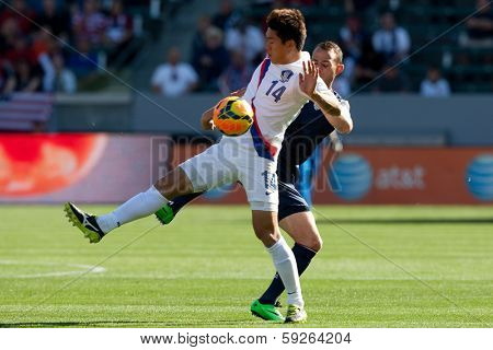 CARSON, CA. - FEB 01: Korea D Yong Lee #14 & USA M Brad Davis #11 during the U.S. mens national team soccer friendly against Korea Republic on Feb 1st 2014 at the StubHub Center in Carson, Ca.