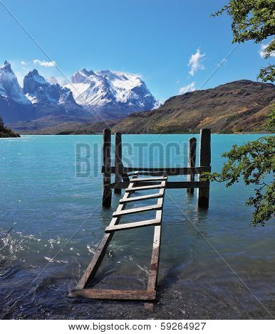 Boat dock on Lake Pehoe. The National Park Torres del Paine, Chile. On the opposite side of the lake majestic snow-capped cliffs of Los Kuernos.