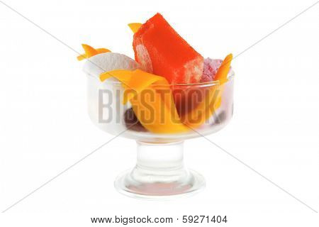 small transparent glass cup with ice cream and tropical fruits isolated on white background