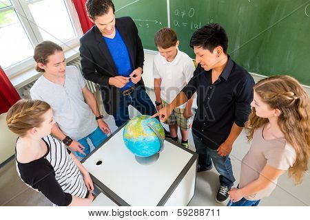 School Students or pupils or mates having group work while geography lesson and the teacher test or educate them in school or class
