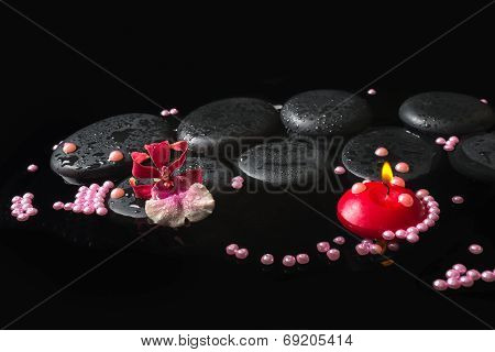 Spa Setting Of Orchid Cambria Flower On Zen Stones With Drops, Pearl Beads And Red Candles In Reflec