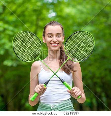 Sport Woman With Badminton Rackets In The Park