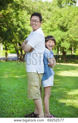 Father And Daughter Standing Back To Back