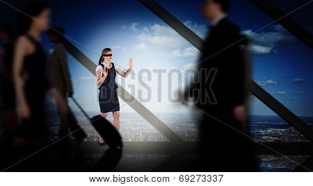 Redhead businesswoman in a blindfold against room with large window looking on city