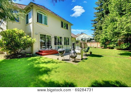 Suny Green Backyard With Yellow Hosue.