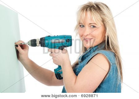 Młoda blond kobieta działa z wiertarko-wkrętarki elektryczne