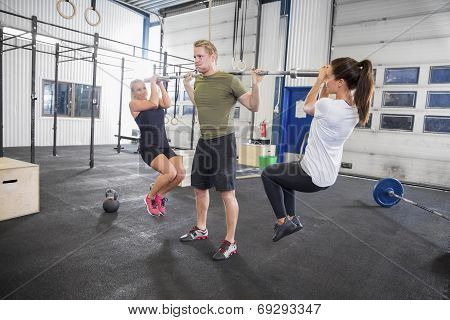 Man trains squats with girls as weights