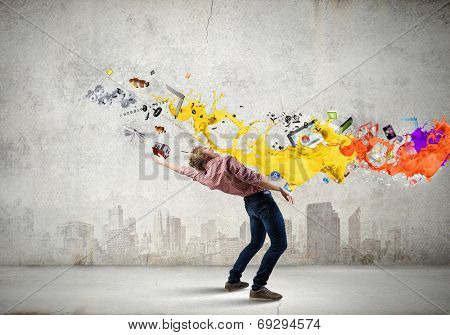 Young man in casual evading from flying icons