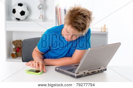 Boy Is Using Smartphone And Computer