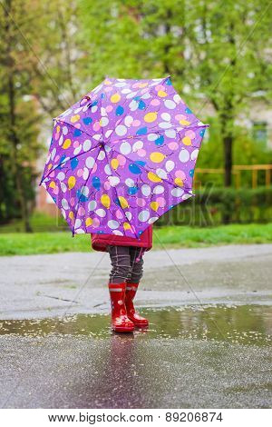 Back view of toddler girl with umbrella