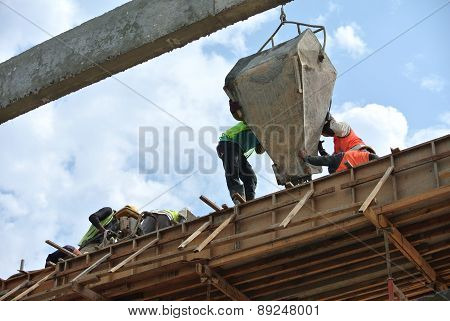 Group of construction workers casting beam