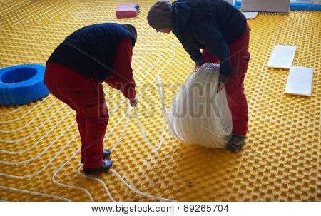 group of workera installing underfloor heating and colling in modern home
