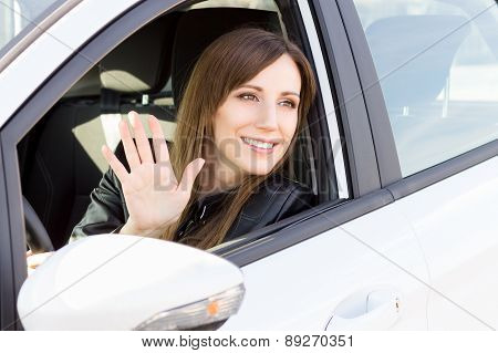 Young Smiling Woman Greeting With Hand From Car.