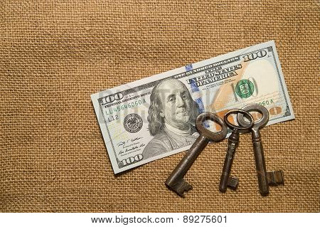Us Dollar Banknotes And Vintage Keys On An Old Cloth
