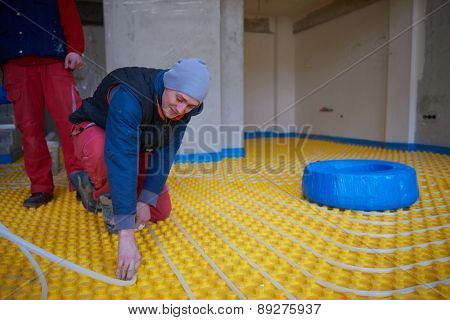 group of workera installing underfloor heating and colling in modern home