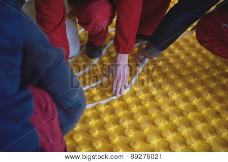 group of workera installing underfloor heating and colling in modern home