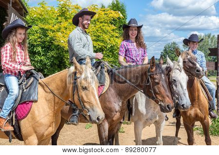 cowboy family of four on horses