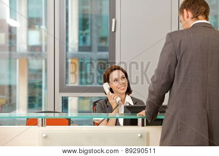 Young caucassian secretary assisting businessman