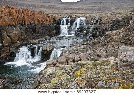 Landscape With Rocks And A Waterfall.