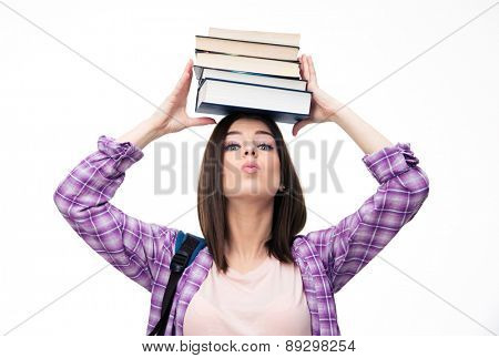 Young wowan holding books on head over white background and looking at camera