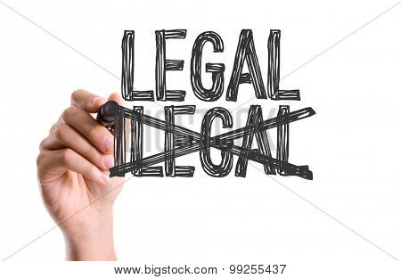 Hand with marker writing the word Legal/Ilegal