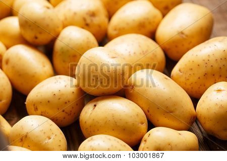 Fresh organic young potatoes on wooden background